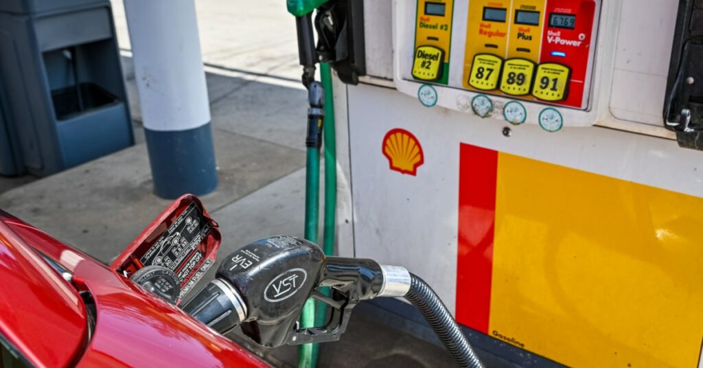 station service Shell avec une voiture rouge en train de faire le plein d'essence